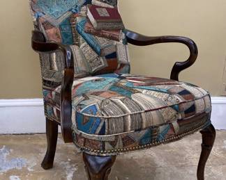 a Queen Anne style armchair featuring a unique tapestry-style fabric pattern depicting various books