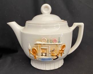 a vintage Porcelier teapot from the 1930s or 1940s, crafted from vitreous china and decorated with a raised "hearth" or colonial fireplace scene