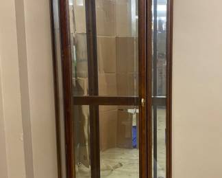 a vintage, lighted corner curio display cabinet, likely produced by a brand such as American of Martinsville or Jasper Cabinet Co