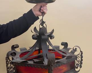 a vintage Spanish Revival wrought iron hanging pendant light with red glass
