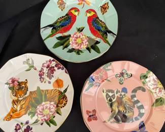 collectible plates are part of the Anthropologie Home Nathalie Lete collection, specifically the Titania dessert plate series featuring whimsical jungle-inspired fauna like lemurs, parrots, and tigers on botanical backgrounds