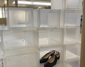Many stackable transparent shoe boxes with drop-down door