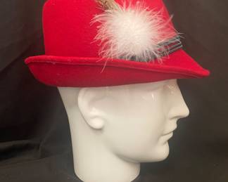 a red Bavarian German-style Alpine felt fedora hat, featuring a decorative rope band, a feather, and feather pin
