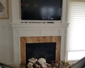 Flat screen TV with bracket; gas fireplace insert; artful decor