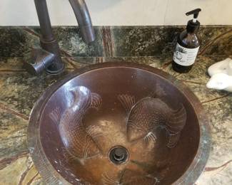 Sinks are copper with embossed fish motifs