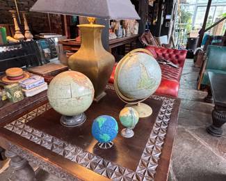 carved mahogany side table, assortment of globes, bronze table lamp