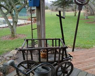 Old harvest wagon. Never in the rain. Galvanized water can. Cast iron bell