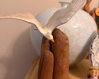 Carved wood seagull on pilings sculpture