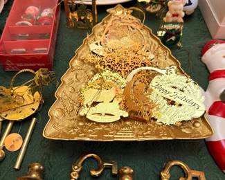 Assorted Christmas decor: brass candle holders, gold foil ornaments, Spode-style holiday plate