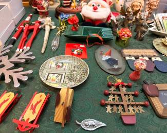 Assorted Christmas decor: mini sleds, plates, ornaments, plush Santa