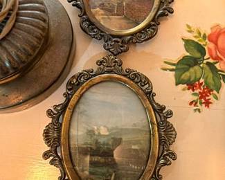 Pair of ornate gilt frames with landscape paintings