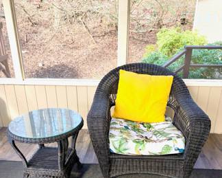 Outdoor wicker seating set including sofa, armchair, ottoman, and glass-top tables, comfortable and ready for the season.