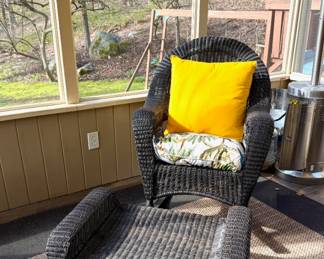 Outdoor wicker seating set including sofa, armchair, ottoman, and glass-top tables, comfortable and ready for the season.