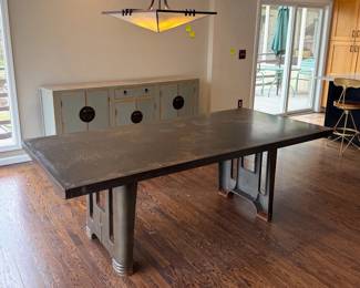 Lillian August industrial dining table with metal base and patinated top.