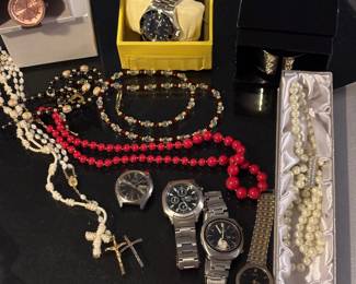 Multiple wristwatches and necklaces