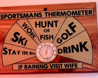 Plaque featureing a dial thermometer and screen-printed activities ranging from golf and skiing to drinking. 