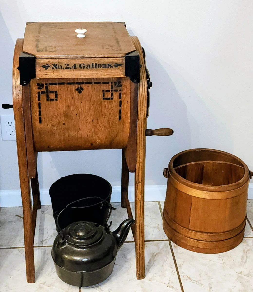 Antique primitive butter churn, cast iron tea kettle, cast iron pot, and wooden divided bucket