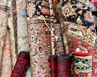 A dense grouping of rugs with varied patterns