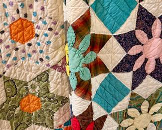Multiple vintage quilts.