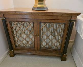 Regency style brass-inlaid side cabinet featuring brass grille doors with silk lining. Excellent condition!