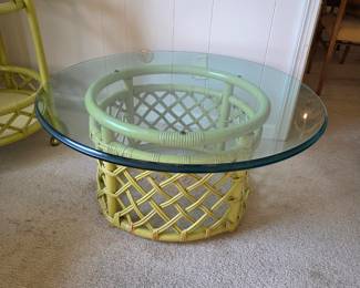 vintage Ficks Reed rattan coffee table features a woven base and a circular glass top. 