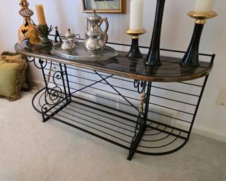 French Provincial baker's rack featuring wrought iron construction with brass trim accents and a glass top. 