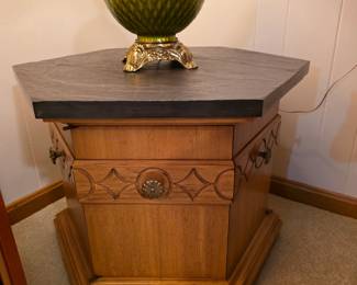 hexagonal accent table appears to be a vintage piece, possibly from the Drexel Esperanto collection, featuring a distinct slate top and storage cabinet. 