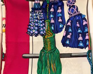 Luxury silk scarf from the French fashion house Hermès. Specifically, this is the "Passementerie" design, created by artist Marie-Françoise Héron and first issued in 1960. The term passementerie refers to the elaborate art of making decorative trimmings, and the motif features a variety of ornate French tassels, braids, and cords