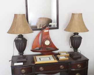 Wood vanity desk, traditional vanity table, dark wood desk, bedroom vanity, writing desk, vintage style desk, solid wood furniture, classic furniture, storage desk with drawers, kneehole desk Matching wall mirror, framed mirror, wood framed mirror, traditional mirror, bedroom mirror, vanity mirror Table lamps, matching lamp set, urn style lamps, traditional lamps, bedside lamps, accent lighting, neutral lamp shades Nautical décor, sailboat décor, wooden sailboat, coastal décor, beach house style décor, decorative clock Picture frames, gold frames, framed photos, home décor accents Bedroom furniture, traditional bedroom set, classic home furnishings, estate sale furniture, vintage inspired décor