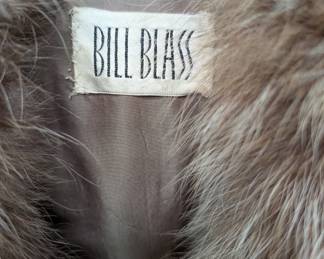 Close up of the vintage Bill Blass brown, cream, and orange striped Penny Lane style coat with plush, exaggerated fur collar and two front pockets. 