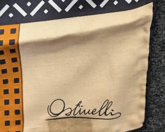 Closeup of vintage Ostinelli silk scarf, pale gold with black and orange geometric pattern