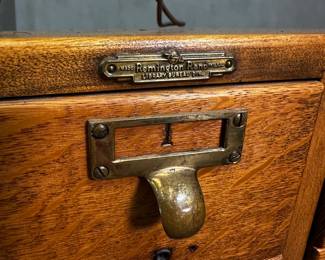Closeup of the antique early 20th century 12-drawer oak Remington Rand library cabinet on original casters 