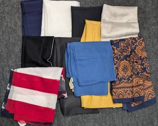 A selection of scarves in various solid colors and patterns including navy, black, cream, blue, red and white stripes, and paisley