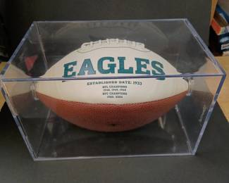A Philadelphia Eagles commemorative logo football featuring the team's championship history printed on the white panel. 