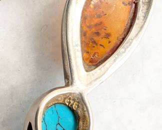 Closeup of the sterling silver choker necklace with bezel-set amber and turquoise