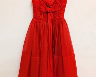 Back view of the vintage 1950s red chiffon cocktail dress with spaghetti straps and a tea-length skirt, the fitted and ruched bodice decorated with rhinestones.