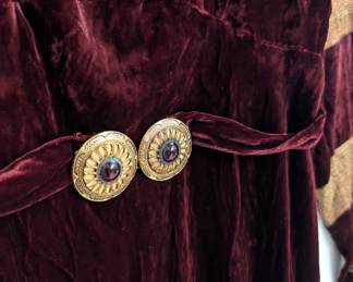 Closeup of the vintage long-sleeved wine-colored velvet and gold knit striped dress, belted at waist with gold tone buckle  