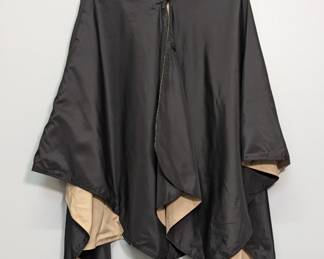 A Raincaper women's black and tan hooded rain poncho