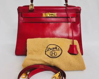 A beautiful 1993 vintage Hermès Kelly Retourne 32 handbag in rouge box leather, authenticated by Entrupy. It comes with a single rolled handle, a removable shoulder strap, and dust bag.