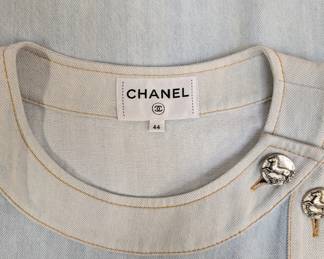 Closeup of the Chanel Paris-Greece collection light blue denim shift dress featuring cap sleeves and silver-tone CC logo buttons, size 44