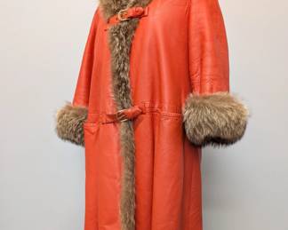 A fabulous 1960s Bonnie Cashin for Sills orange leather & raccoon fur coat, two gold buckles across the bust and the waist; lined with faux orange shearling, with Broms label (Broms Furs, Peoria, Illinois)