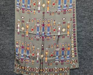 A printed scarf featuring a design inspired by Navajo Yei figures