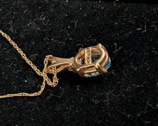 Closeup of 10k yellow gold and blue topaz pendant necklace