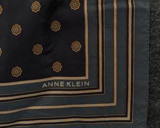 Closeup of an Anne Klein silk square scarf featuring a black and gold floral pattern with a bordered design
