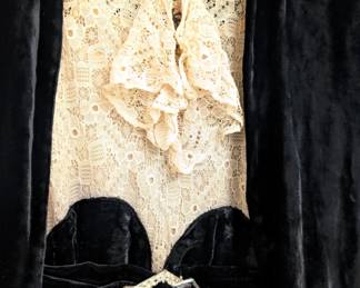Closeup of the vintage black velvet dress and jacket set, the dress with ecru lace bodice, silver-tone and rhinestone buckle at the waist
