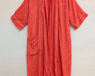 A vintage coral or reddish-orange color robe made in Japan, with floral pattern embroidery and white piping along the collar, cuffs, and pockets