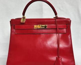 Another view of the beautiful 1993 vintage Hermès Kelly Retourne 32 handbag in rouge box leather, authenticated by Entrupy. It comes with a single rolled handle, a removable shoulder strap, and dust bag.