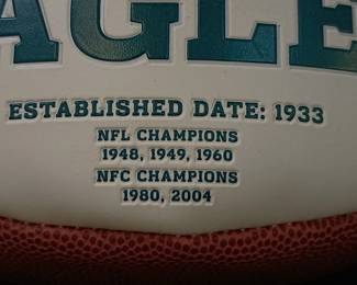 Closeup of the Philadelphia Eagles commemorative logo football featuring the team's championship history printed on the white panel. 