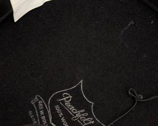 Closeup of the vintage Fabini New York black wool felt hat with a wide brim, ribbon band and netting veil