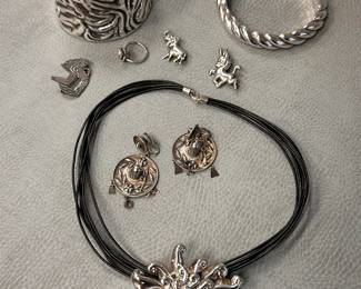 Charming pair of vintage Mexican sombrero silver earrings, a vintage modernist silver tone start burst or "chrysanthemum" pendant on a multi-strand black cord necklace, a FLAMES hand-forged embossed antiqued wide pewter cuff bracelet, and more